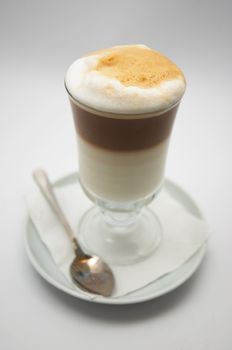 glass mug of just brewed coffee frappe with crisp foam. very shallow dof.