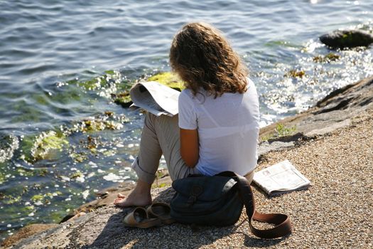 Young girl reading newspaper.