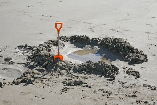 Gone for a swim? Shovel left alone after digging in the sand. Italian beach.