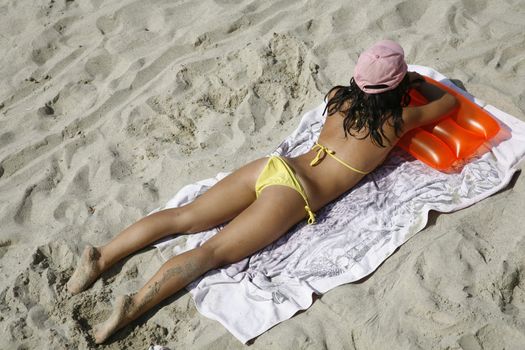 Young beautiful Italian girl relaxing in the sand.