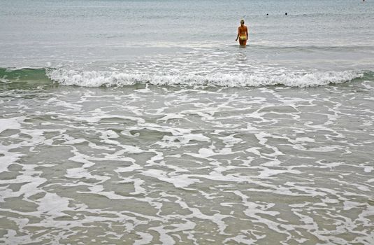 Bikini girl going to have a swim in the Mediterranean.