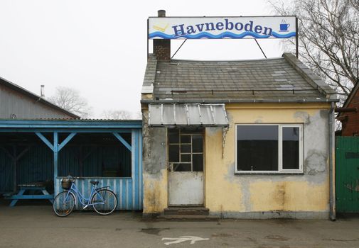 Old Danish abandoned coffee shop in a harbor area.