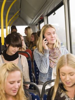 Young woman on the phone while going by the bus