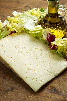Asiago cheese with fresh salad on wooden table