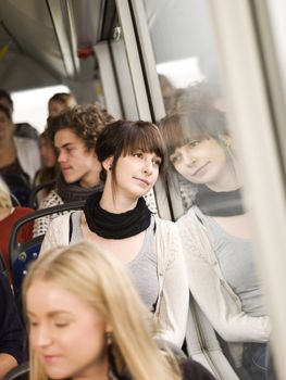 Young woman on the bus with large group of people