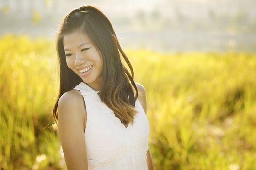 Asian bride at outdoor in a morning surrounding by golden sunlight