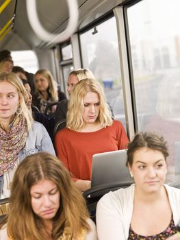 Serious woman on the bus with a computer