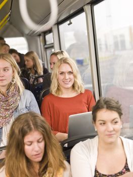 Happy woman with computer on the bus