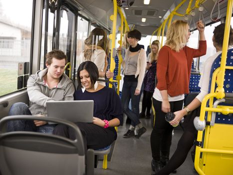 Couple with computer going by bus