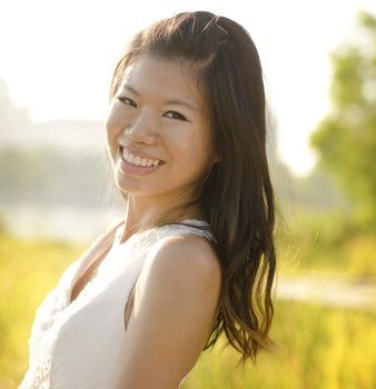 Asian bride at outdoor in a morning surrounding by golden sunlight