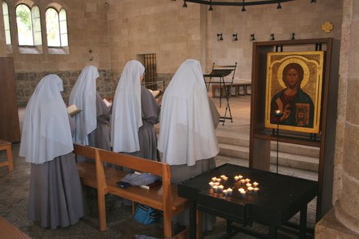 View of praying nuns inside The Church of the Multiplication of the Loaves and the Fishes, Tabgha, Israel