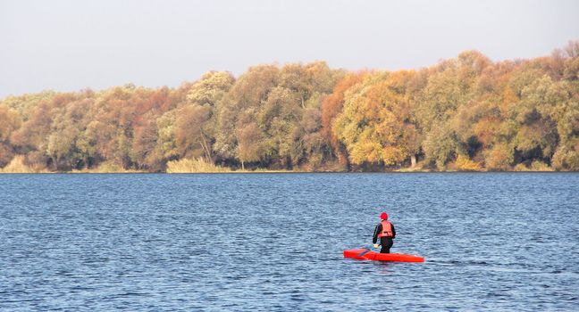 Sportsman in a red canoe. Fall
