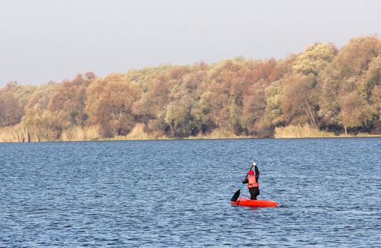 Sportsman in a red canoe. Autumn