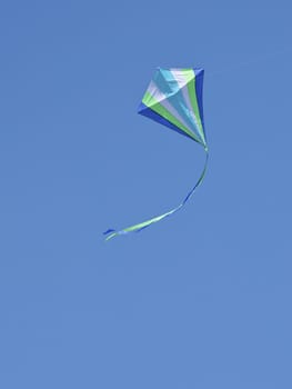 Stripped kite flying in the blue sky, fun for children 