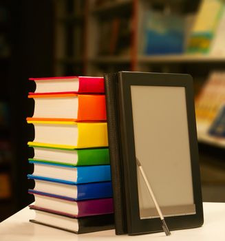 Stack of books with electronic book reader