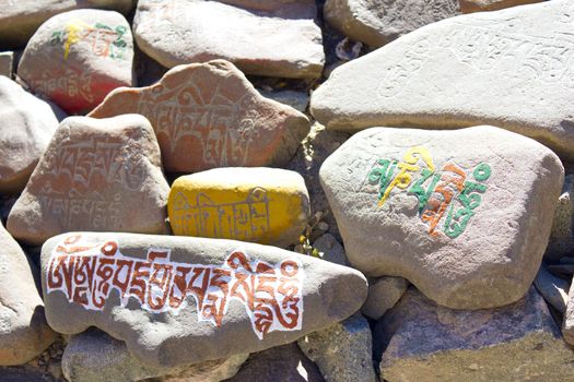 stones in the mountains with written on them Buddhist mantras