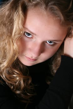 Beautiful teen with curly hair against a black background