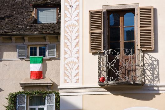 Italian flag on window with balcony in foreground