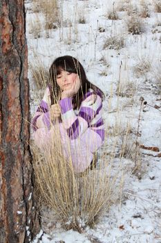 Young brunette teen playing in the field after the snowfall
