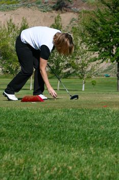 Blond female golfer setting up her golf shot