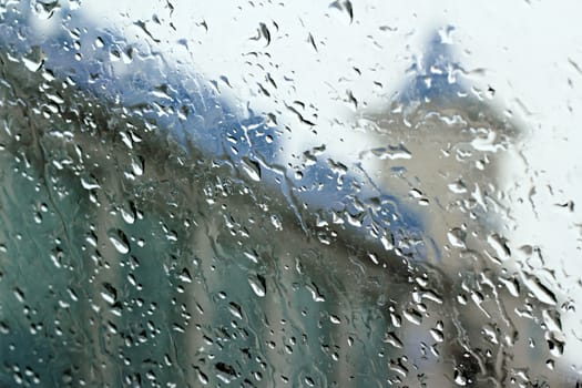 View of the street through the glass topped with rain