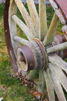 Rustic worn wooden wagon wheel on grass