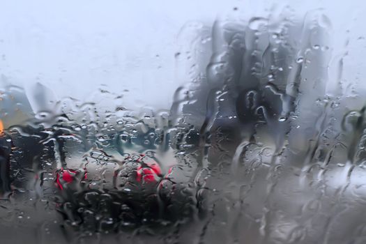 View of the street through the glass topped with rain