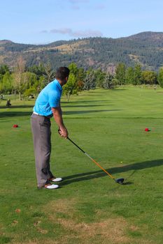 Young male golfer preparing for his tee-shot