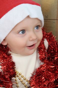 Cute baby boy wearing a christmas hat playing with decorations