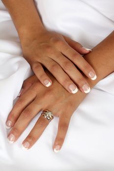 Native brides hands on her white wedding gown