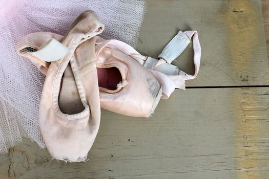 Worn pointe shoes on a pink net tutu