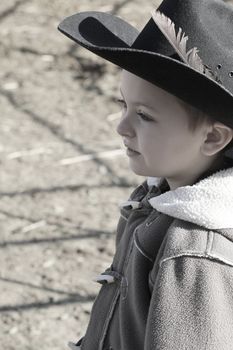 Young cowboy wearing a hat and fleece jacket
