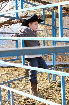 Young cowboy wearing a hat and fleece jacket