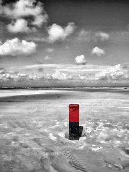 Wooden pole at the Dutch beach b/w and coloured