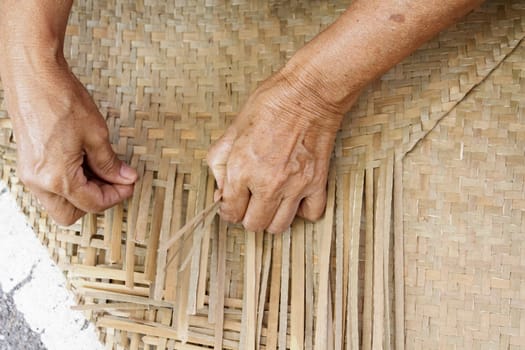 Thai woman hands weaving reed mat