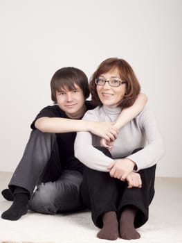 mother and son are together and smile in studio