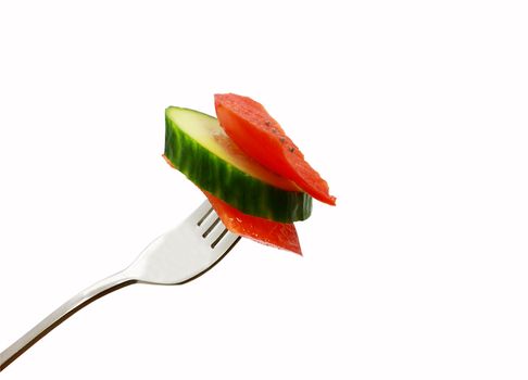 slices of red pepper and cucumber on the fork isolated