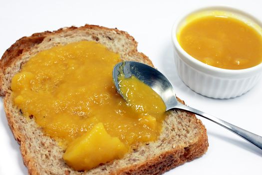 piece of bread with apricot jam isolated on white