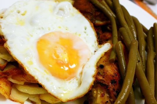 scrambled egg, bean pods and fried potatoes close up