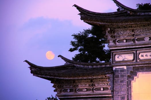 Ancient Chinese architecture over sky and moon, taken at late evening