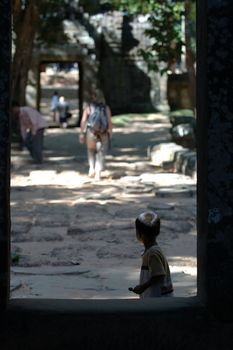 A Cambodia child, returning head and looking at a tourist