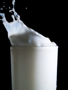 Glass of milk on a black background