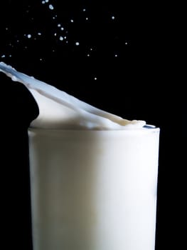 Glass of milk on a black background