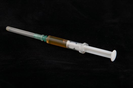 The filled syringe on a black background