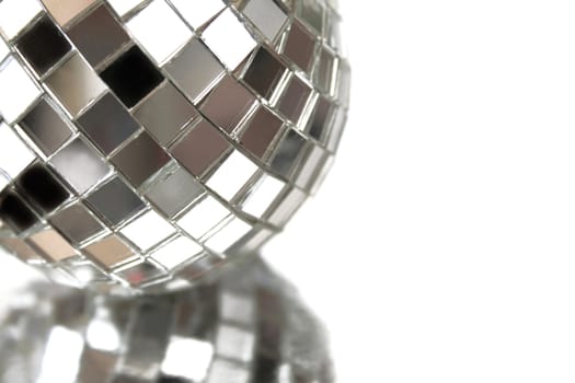Close up of a small disco ball isolated on white with a reflection.