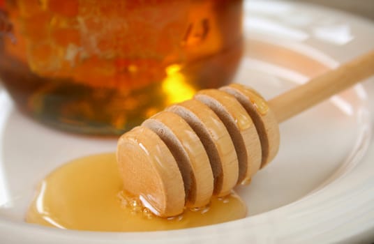 Honey with wooden dipper.