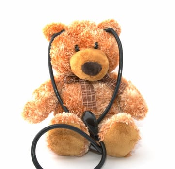 The teddy bear with a stethoscope on a white background