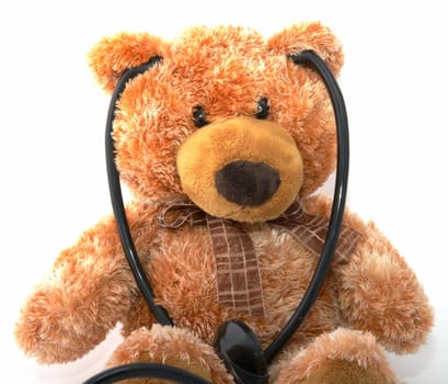 The teddy bear with a stethoscope on a white background