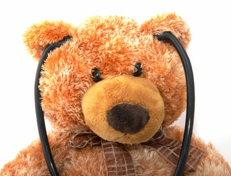 The teddy bear with a stethoscope on a white background