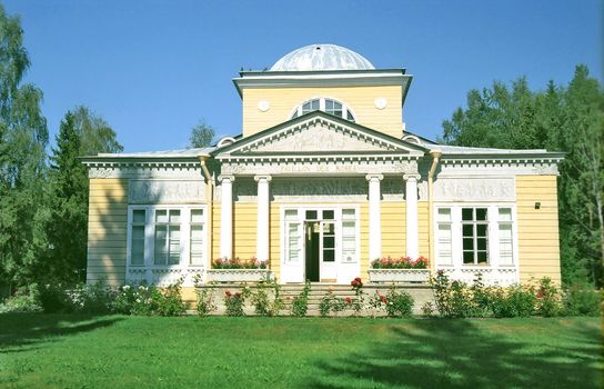 Classical wooden building in front with roses